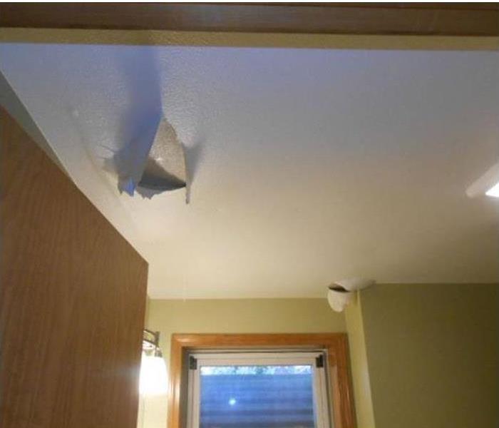 hole with protruding material in a ceiling in a bathroom