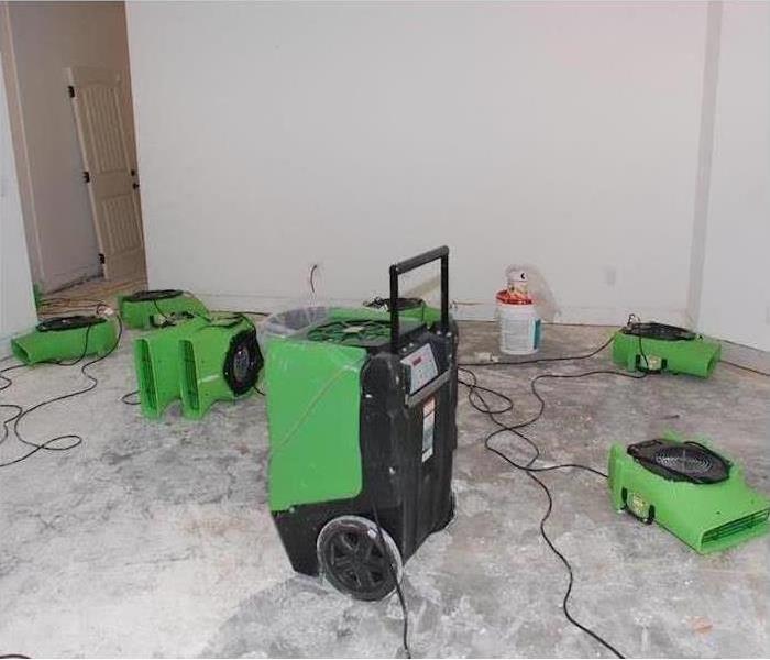 stripped floor to concrete, green equipment drying the room